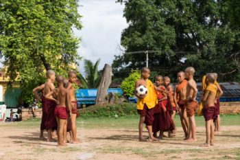 Die Nachwuchs-Mönche beim Fußballspielen vor der zerfallenen Pagode