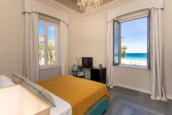 Hotelzimmer mit Bett und Blick auf den Strand