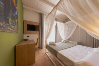 Hotelzimmer mit Himmelbett und hellgrünen Wänden