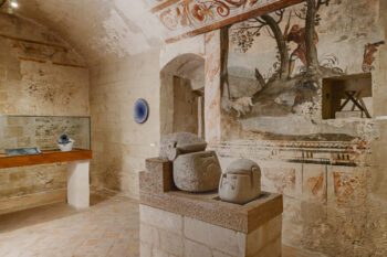 Gewölbter Raum mit Fresken und Vasen-Skulpturen