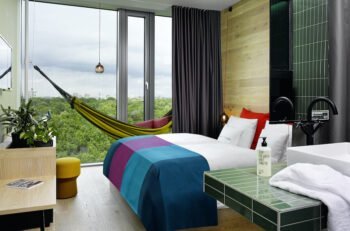 Hotelzimmer mit Bett, Hängematte und raumhohes Fenster