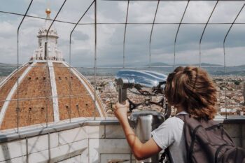 Junge siehst vom Glockenturm durch Fernglas auf den Dom von Florenz