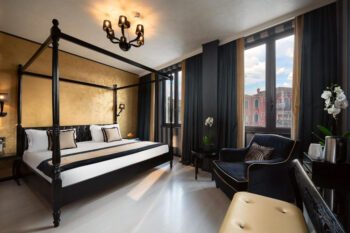 Himmelbett in Hotelzimmer in Venedig mit Kronleuchter