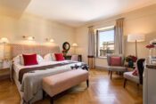 Warm eingerichtetes Zimmer mit roten Farbakzenten im Hotel Savoy in Florenz