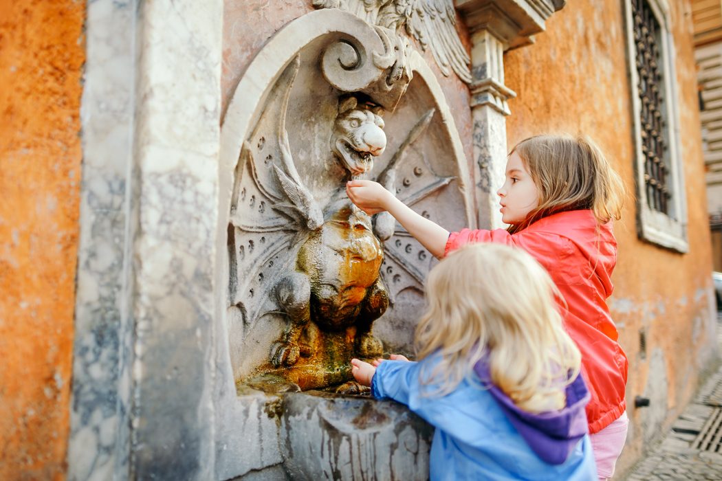 Spielende Kinder in Rom an einem Wasserbrunnen