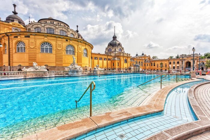 Neobarockes Gebäude der Szechenyi Therme in Budapest, mit Pool im Vordergrund