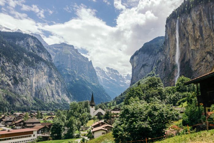 Lauterbrunnental in der Schweiz mit hohen Bergen rechts und links, einem Wasserfall und einem Dort