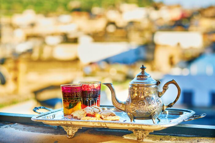 Teekanne und Gläser mit Minztee auf Terrasse in Marrakesch