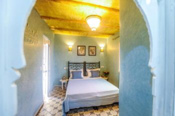 Zimmer in Riad mit Bett und hellblauen Wänden