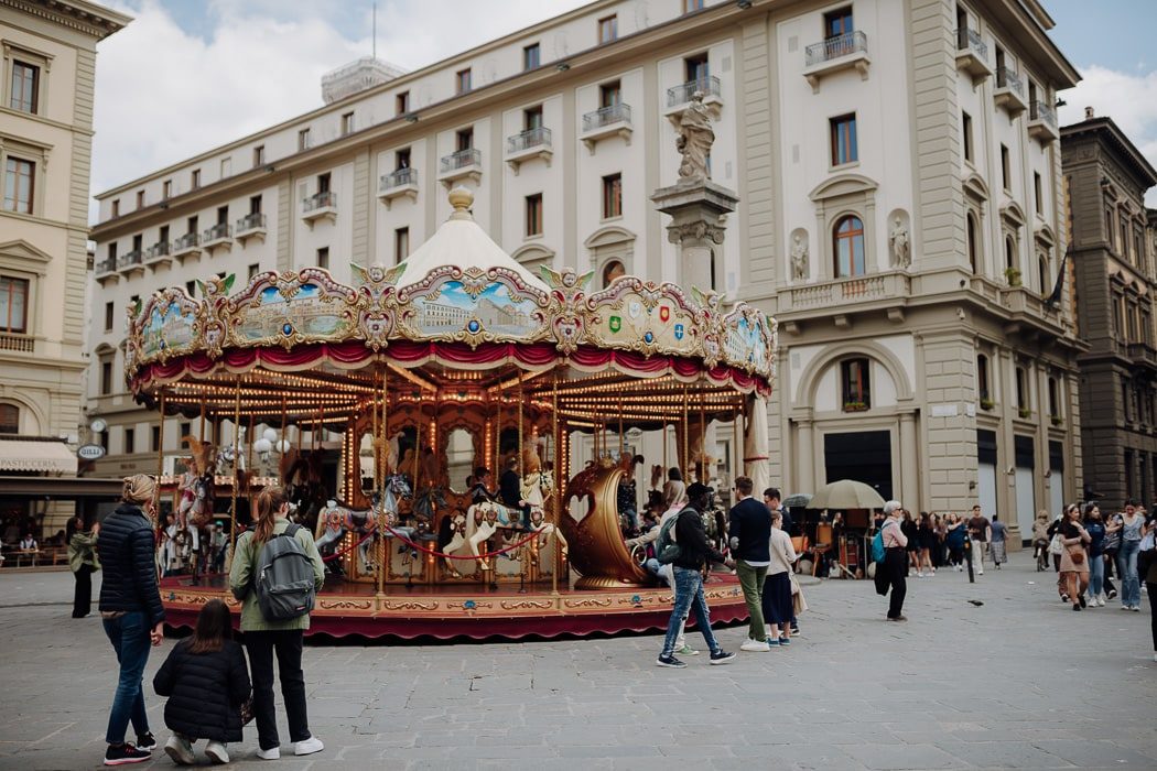 historisches Karussell mit Menschen davor in Florenz
