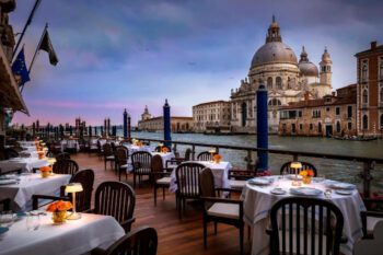 Hotelterrasse mit Tischen mit Blick auf Santa Maria della Salute in Venedig