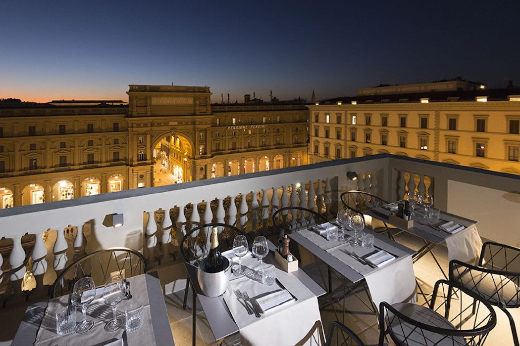 Rooftop Bar mit gedeckten Tischen und Blick auf Piazza della Repubblica in Florenz