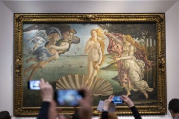 Erhobene Hände mit Smartphones die die Venus von Botticelli in den Uffizien fotografieren