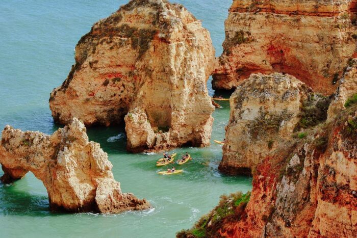 Kajakfahrer zwischen den Felsen an der Ponta da Piedade, Algarve