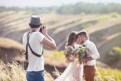 Hochzeitsfotograf macht Foto von Brautpaar in der Natur