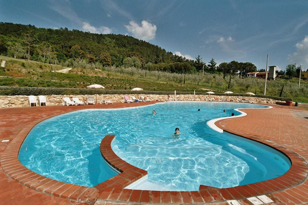 Grosser pool mit kindern und olivenbäumen im hintergrund