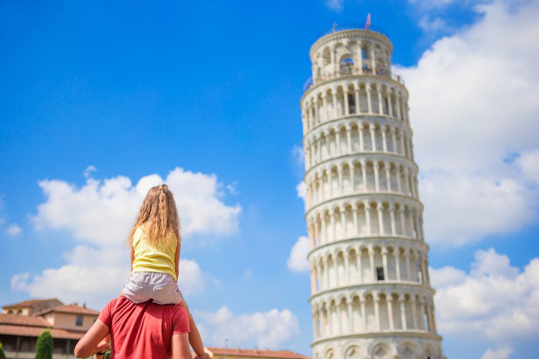 Blondes Mädchen von hinten auf den Schultern des Vaters mit Schiefen Turm von Pisa im Hintergrund