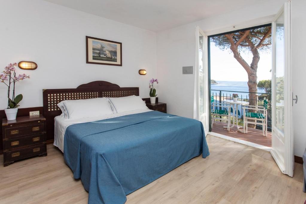 Hotelzimmer mit Doppelbett und offener Tür zum Balkon mit Blick aufs Meer