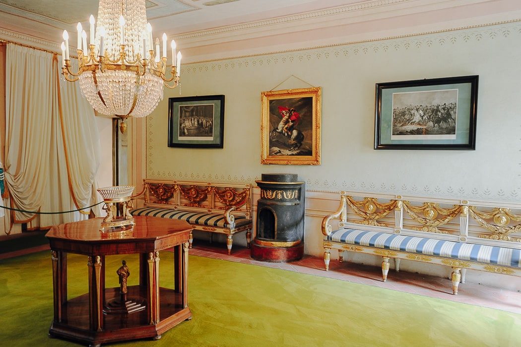 Zimmer mit Einrichtung aus 19. Jahrhundert, mit Kronleuchter, Gemälden und Sitzbänke