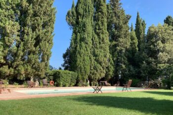Großer Garten mit Zypressen, Rasen und Pool