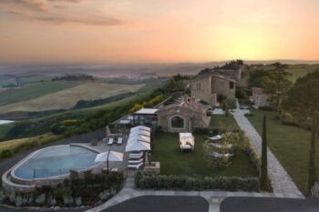 Aussicht auf das Weingut und eine weitläufige Landschaft der Capanna Suites in der Toskana bei Sonnenuntergang