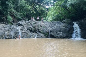 Wasserfall mit Menschen an einer niedrigen Felswand in Montezuma in Costa Rica