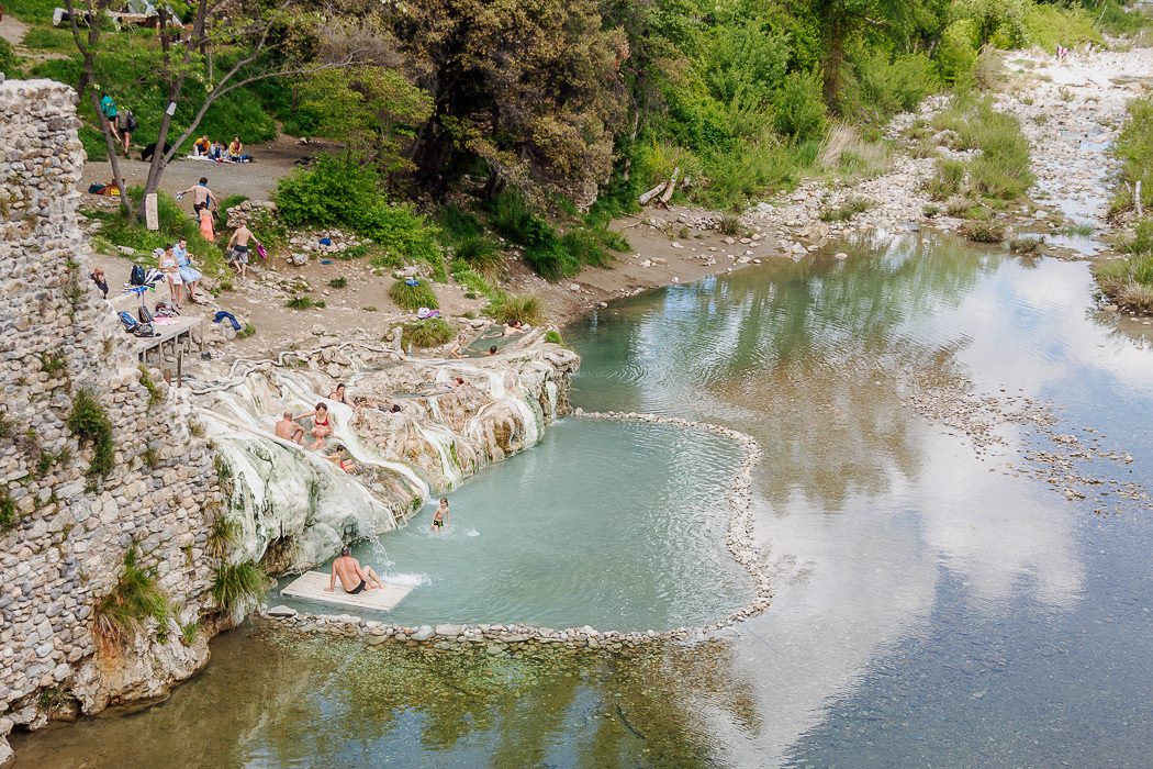 Menschen baden in Wasserbecken im Wald bei einem Fluss