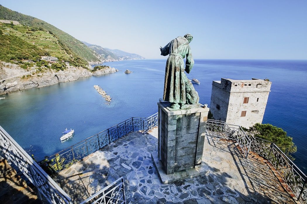 Statue von hinten mit Blick auf Meer und Landschaft