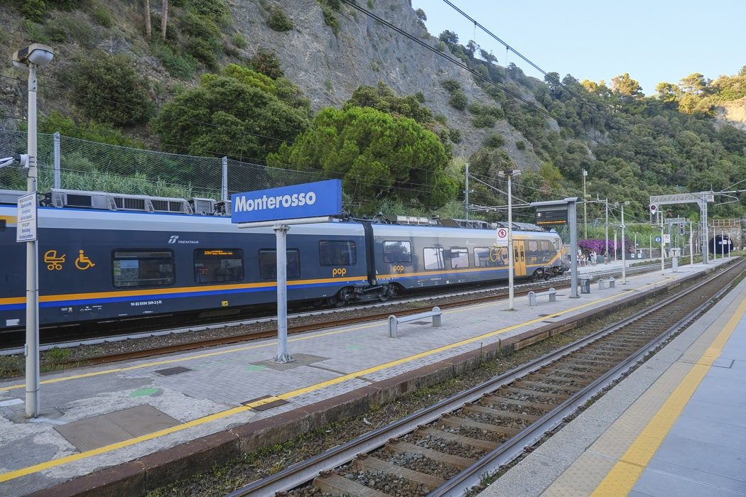Bahnhof mit stehendem Zug und Schild mit Monterosso