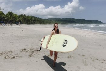 Frau mit Surfbrett am Playa Carmen in Santa Teresa in Costa Rica