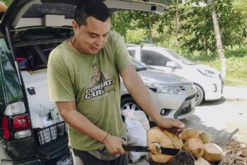 Ein Mann öffnet eine Kokosnuss mit dem Messer in Santa Teresa in Costa Rica
