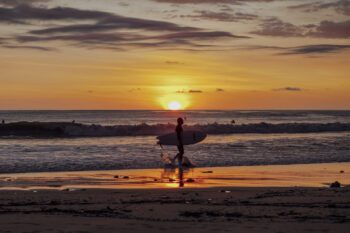 Surfer am Strand von Santa Teresa in Costa Rica bei Sonnenuntergang