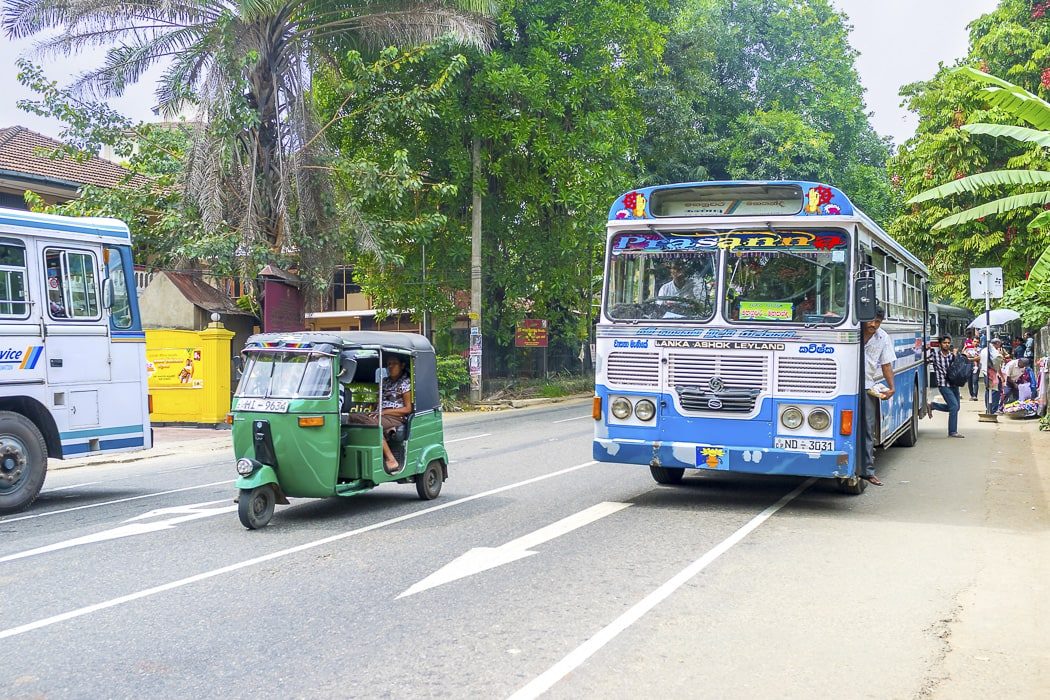 Busse und Tuk Tuk auf einer Straße in Sri Lanka