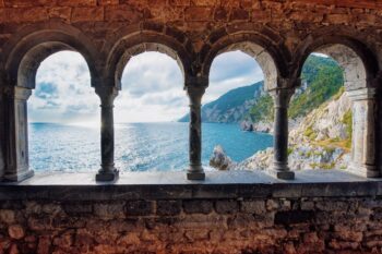 Säulenfenster mit Blick auf Küste und Meer