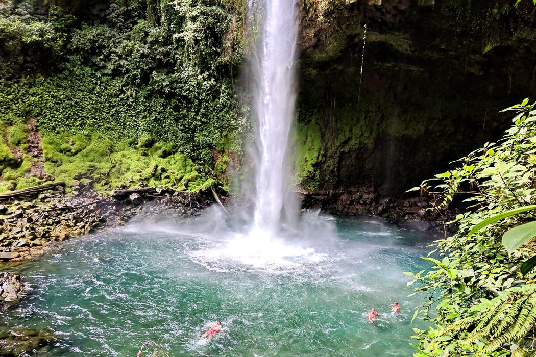 Menschen schwimmen im Becken des La Fortuna Wasserfalls in Costa Rica