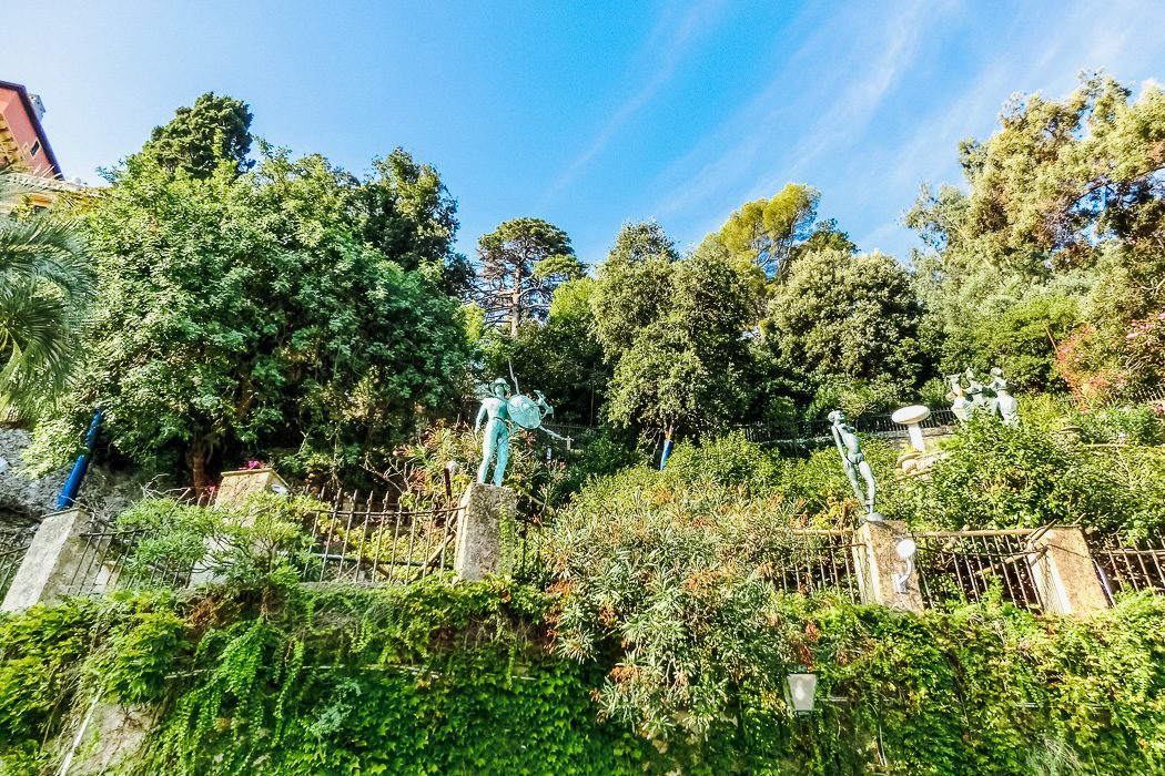 Steil angelegte Gartenanlage mit viel Grün und Skulpturen
