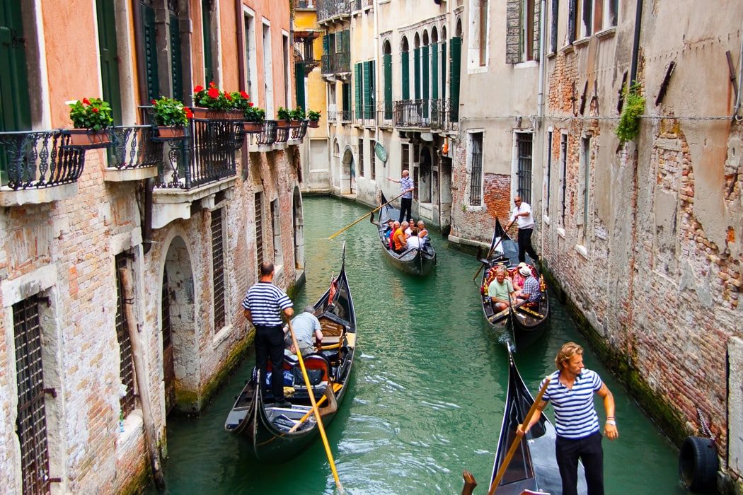 Blick auf Kanal von Venedig mit mehreren Gondeln mit Touristen