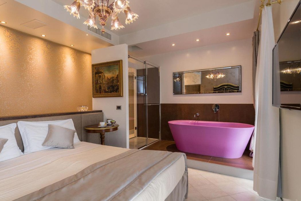 Zimmere mit Doppelbett und pinker Badewanne