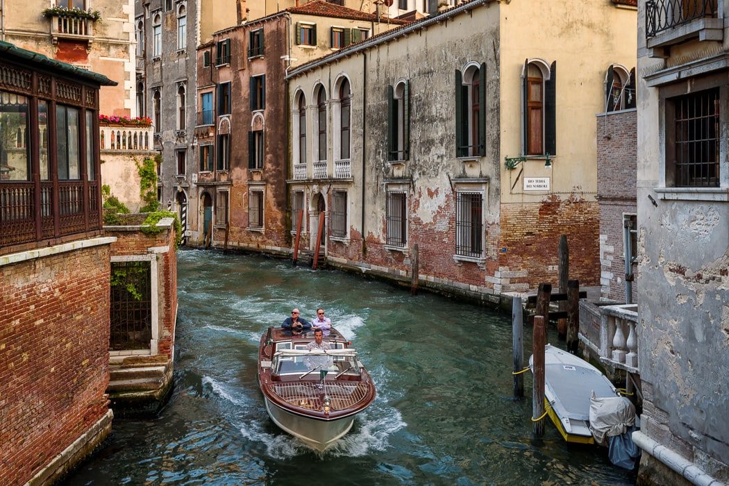 Blick auf Kanal von Venedig mit Motorboot mit Menschen