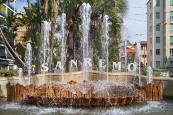 Buchstaben SANREMO über Springbrunnen mit Palmen im Hintergrund