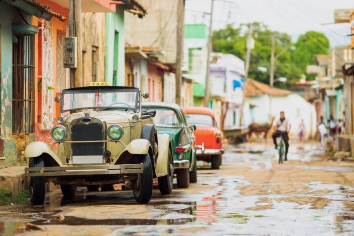 Alte Autos und Wasser, das mitten auf den Straßen abläuft - ganz normal auf Kuba