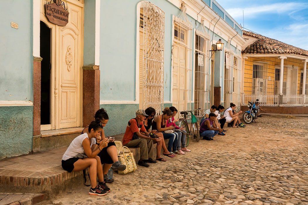 Menschen sitzen am Handy an den öffentlichen WLAN-Zonen auf Kuba