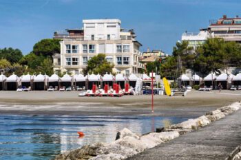 Blick vom Wasser auf Hotel am Strand mit Treetbooten