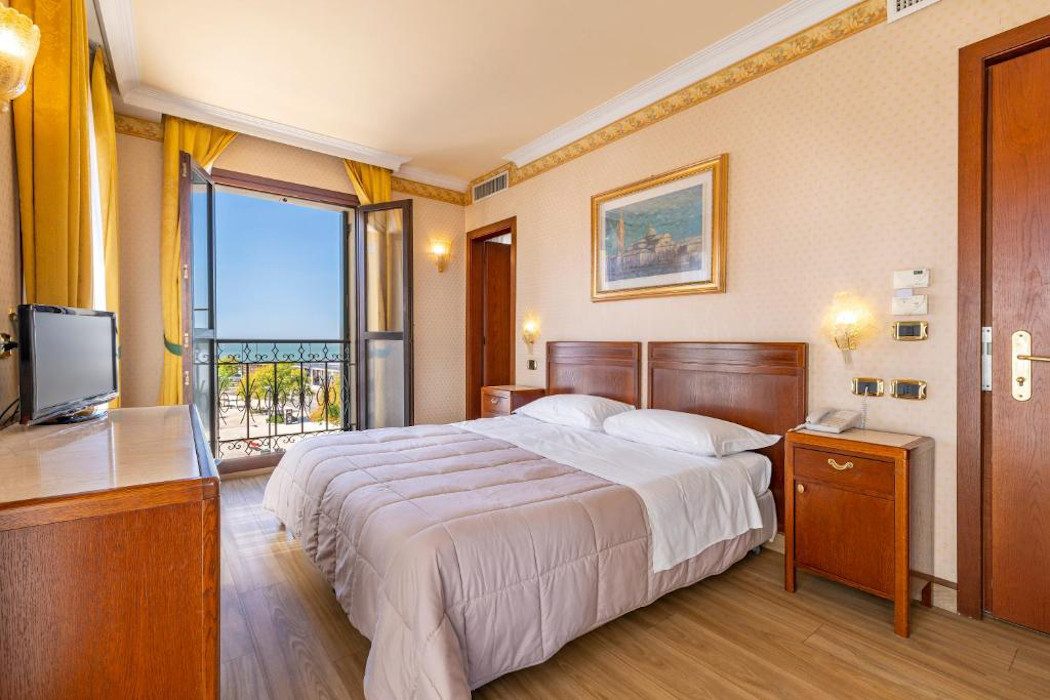 Hotelzimmer im Fünfzigerjahre-Stil mit Doppelbett und Goldtönen