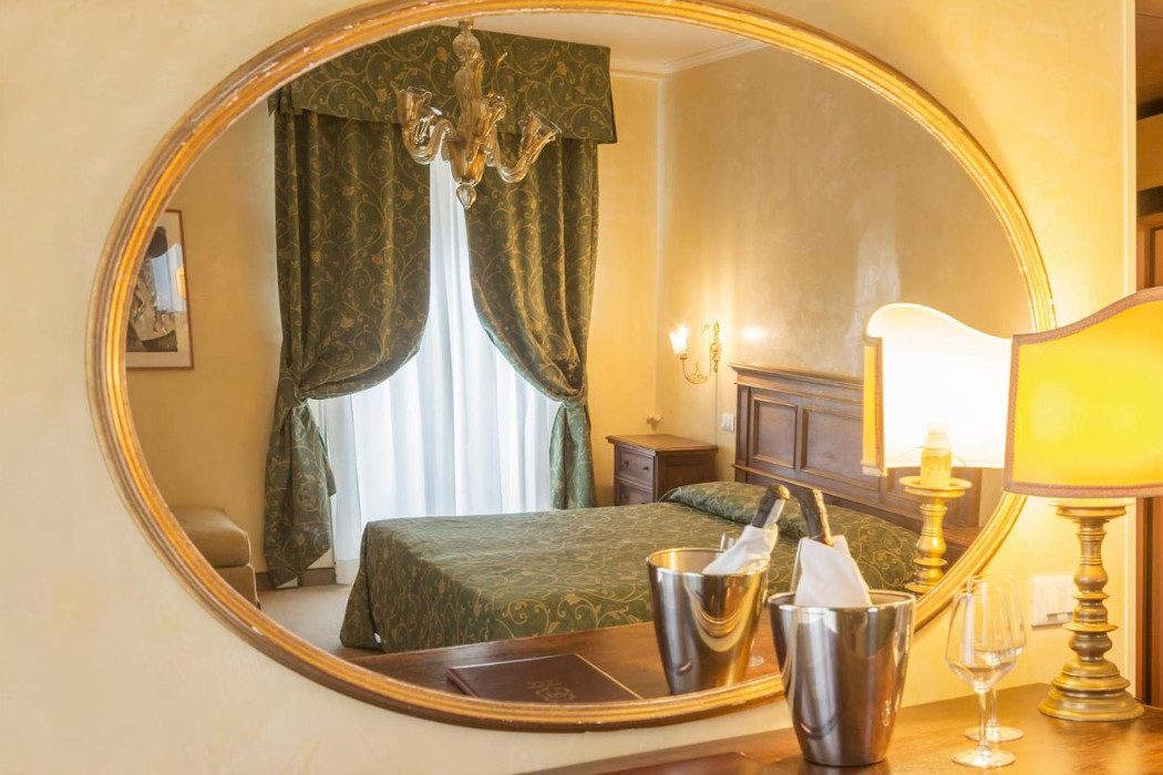 Spiegel mit Spiegelbild mit von Hotelzimmer mit Kronleuchter und klassischen Möbeln